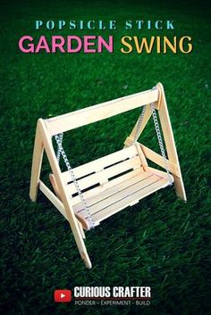 a wooden swing sitting on top of a lush green grass covered field with text reading popsicle stick garden swing curious crafter