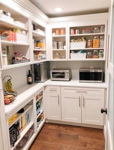 a kitchen with white cabinets and lots of shelves