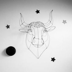 a wire sculpture of a bull's head with stars on the wall next to it