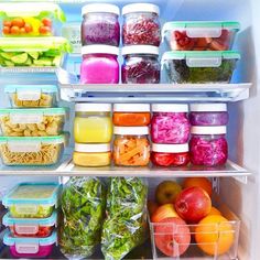 an open refrigerator filled with lots of different types of vegetables and fruit in plastic containers