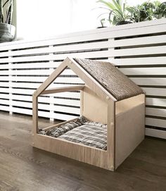 a dog house made out of plywood with a bed in the front and side