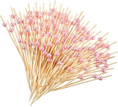 a bunch of pink and white pins on top of each other with wooden sticks in the middle