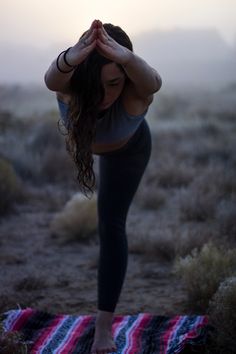 a woman is doing yoga in the desert