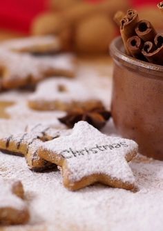 some cookies are laying on the table with snow flakes and cinnamon sticks in front of them