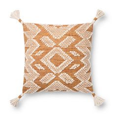 an orange and white pillow with tassels