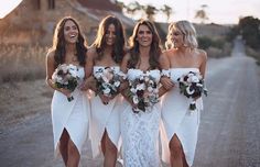 three bridesmaids in white dresses are walking down the road with their bouquets