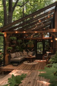 an outdoor living area with wooden decking and lights strung from the roof, surrounded by greenery