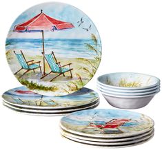 a set of four dinner plates with beach scenes on them and an umbrella in the background