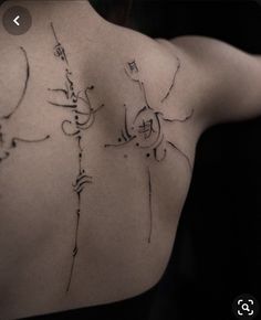 the back of a person's shoulder with some writing on it and an arrow