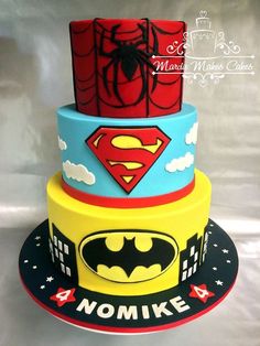 three tiered cake decorated with batman and spiderman symbols