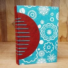 a blue and red notebook sitting on top of a wooden table