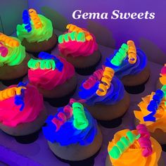 there are many cupcakes with neon lights on them