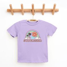 Looking for a cute tee for your kids? We have the perfect Sunkissed Rainbow graphic tee addition to their closet! Also available in toddler tees. Lavender Short Sleeve T-shirt With Graphic Print, Trendy Lavender Short Sleeve T-shirt, Playful Purple Summer T-shirt, Cute Purple Short Sleeve T-shirt, Lavender Trendy T-shirt For Summer, Trendy Lavender T-shirt For Summer, Trendy Lavender Summer T-shirt, Playful Purple Cotton T-shirt, Playful Purple Short Sleeve T-shirt