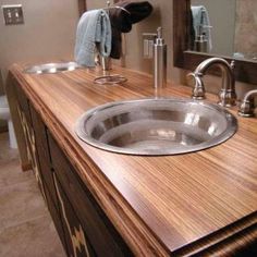 a bathroom with a wooden counter top and sink in it's center area is shown