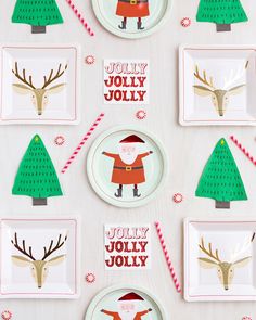 paper plates decorated with santa claus and reindeers are on a white tablecloth, surrounded by christmas decorations