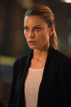 a woman in a white shirt and black blazer looking at the camera with an angry look on her face