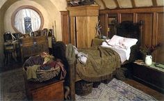 a bedroom with a bed, dresser and mirror in the corner next to an arched doorway