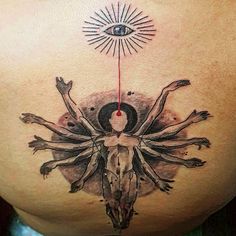 a woman's back with an artistic tattoo design on her stomach and the sun above it