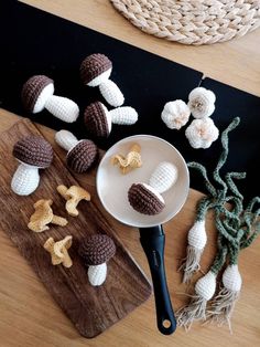 crocheted mushrooms are on a cutting board next to a knife and other items