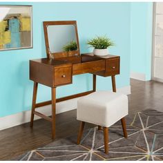 a wooden vanity table with a mirror and stool in front of it on top of a rug