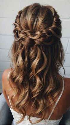 the back of a woman's head with long wavy hair and braid in it