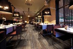 an empty restaurant with wooden floors and tables