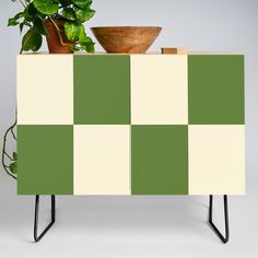 a potted plant sitting on top of a green and white checkerboard cabinet