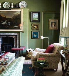 a living room filled with furniture and paintings on the wall above it's fireplace