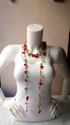 a mannequin wearing a white top with red flowers on it's neck