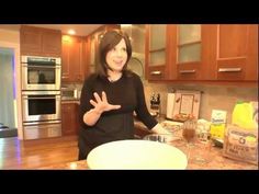 a woman standing in front of a kitchen counter with an empty bowl on the counter