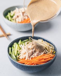 someone pouring dressing over a bowl of vegetables