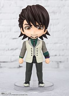 an anime figurine with black hair and green eyes wearing a white vest, standing on