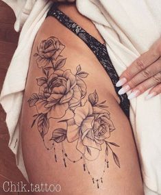 a woman's stomach with tattoos on it and roses in the middle of her belly