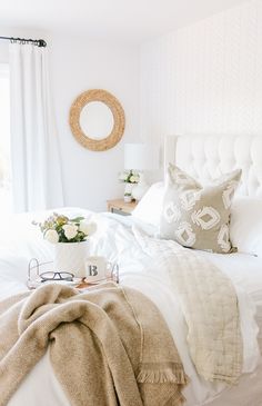 a bedroom with white bedding and pillows