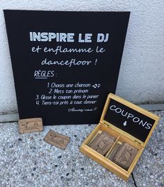 a couple of wooden blocks sitting on top of a sidewalk next to a chalkboard