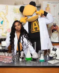 two people in lab coats standing next to each other with beaks and flasks