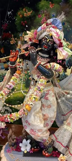 an elaborately decorated statue is shown in this artistic photo, with flowers and other decorations