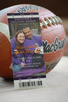 an orange and white striped ball with a ticket for a football game on it's side