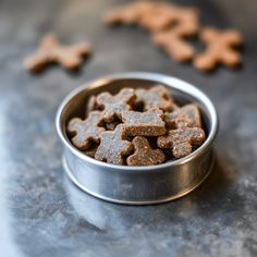 a metal bowl filled with dog treats on top of a table