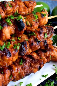 chicken skewers are piled on top of each other and garnished with parsley