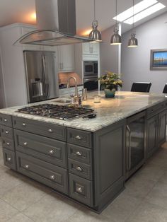 a large kitchen with an island in the middle and two stoves on each side