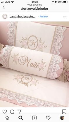 a pink crib with an embroidered name on the front and bottom, along with lace trim around the edges