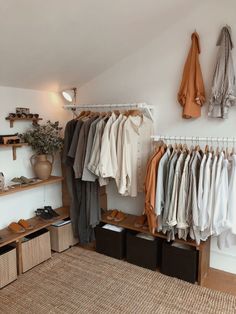 an organized closet with clothes and shoes hanging on the wall, along with storage bins