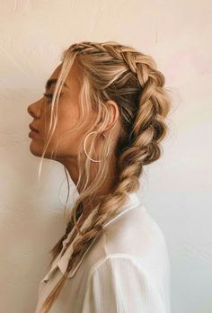 a woman with long blonde hair in a fishtail braid, looking off to the side