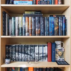 a bookshelf filled with lots of different types of books on top of wooden shelves