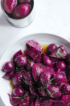 a white bowl filled with beets on top of a table next to a fork