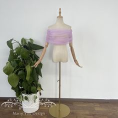 a mannequin is standing next to a potted plant