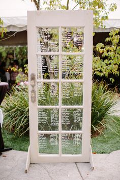 an old window is used as a seating arrangement for a wedding reception at the garden