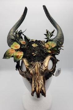 an animal skull with horns and flowers on it's head