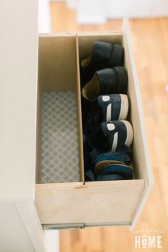 an open drawer with shoes inside of it